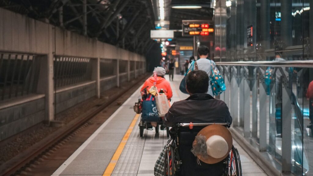 persone in carrozzina che si muovono in stazione dei treni