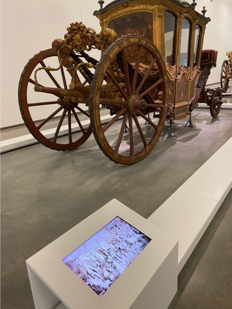 Museo Nazionale delle Carrozze Lisbona: l'immagine di una carrozza e di uno schermo vicino che proietta un video.